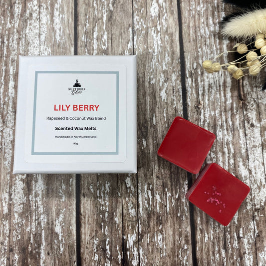 Red wax melts in a white square box sitting on a wood background